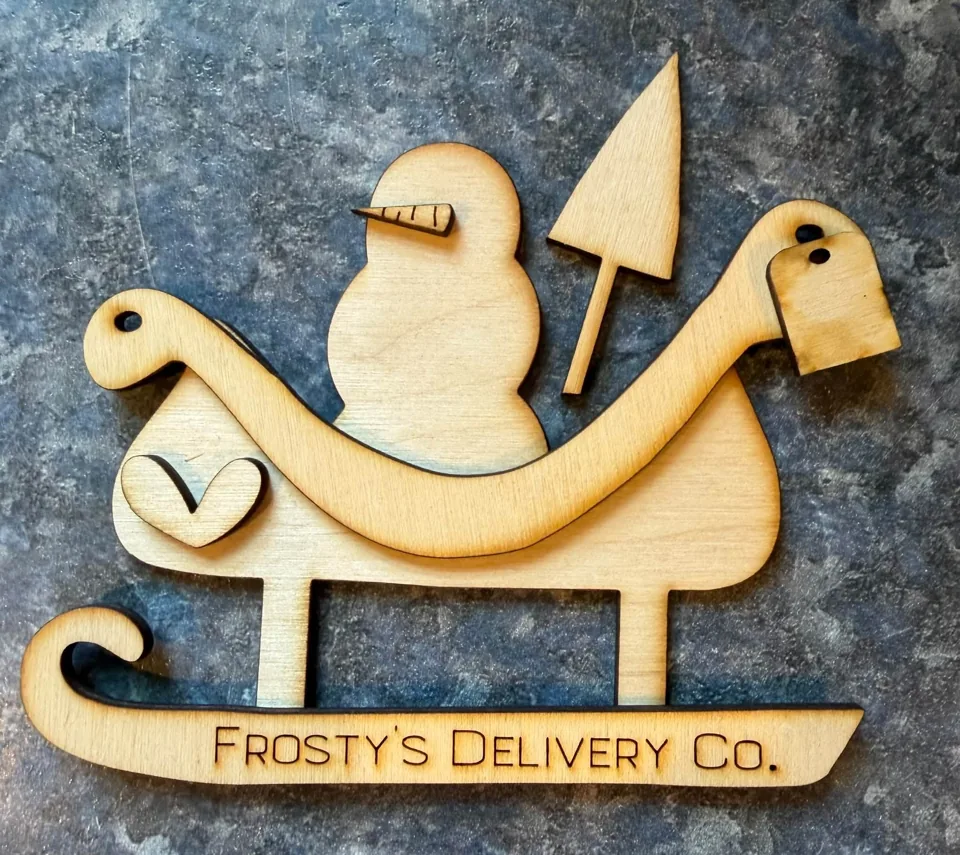 Wooden snowman sleigh with Frosty’s Delivery Co. lettering