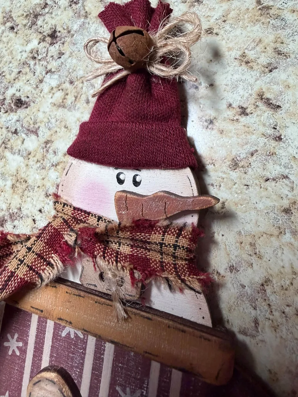Close-up of snowman ornament with twine and plaid scarf