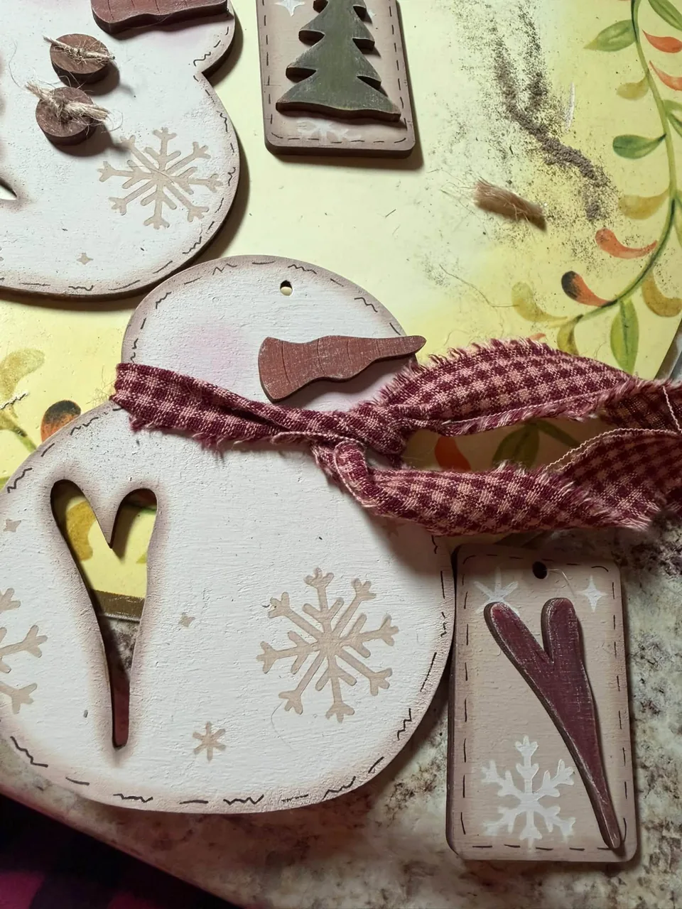 Painted snowman ornament with plaid scarf and heart detail